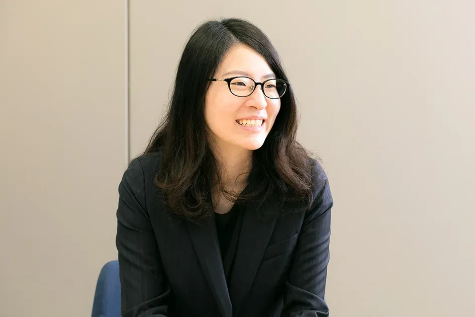 A smiling female Honda employee wearing glasses and a dark blazer.